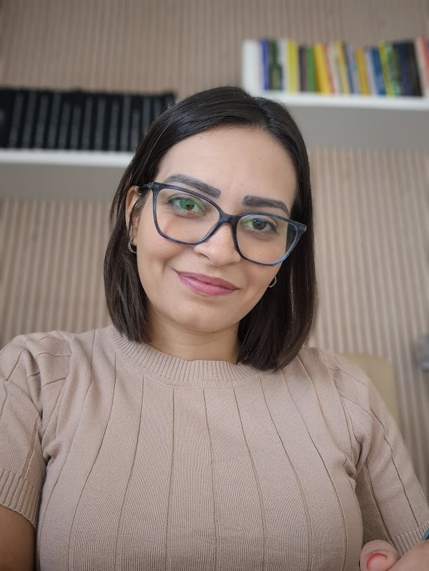 Thais Souza, de blusa bege, em seu espaço de trabalho